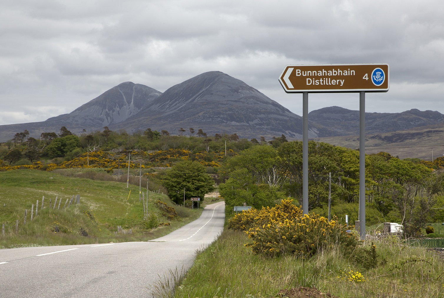 The Sign For Bunnahabhain Distillery On The Isle Of Islay, Inner Hebrides, With A View To The Paps Of Jura Behind