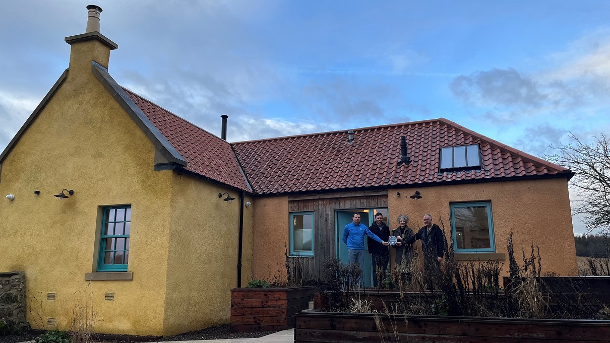 Four people standing outside Brucefield Estate, a self catering cottage in Clackmannanshire.