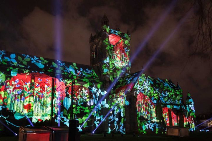 Paisley Abbey illuminated with projection of flowers and plantlife