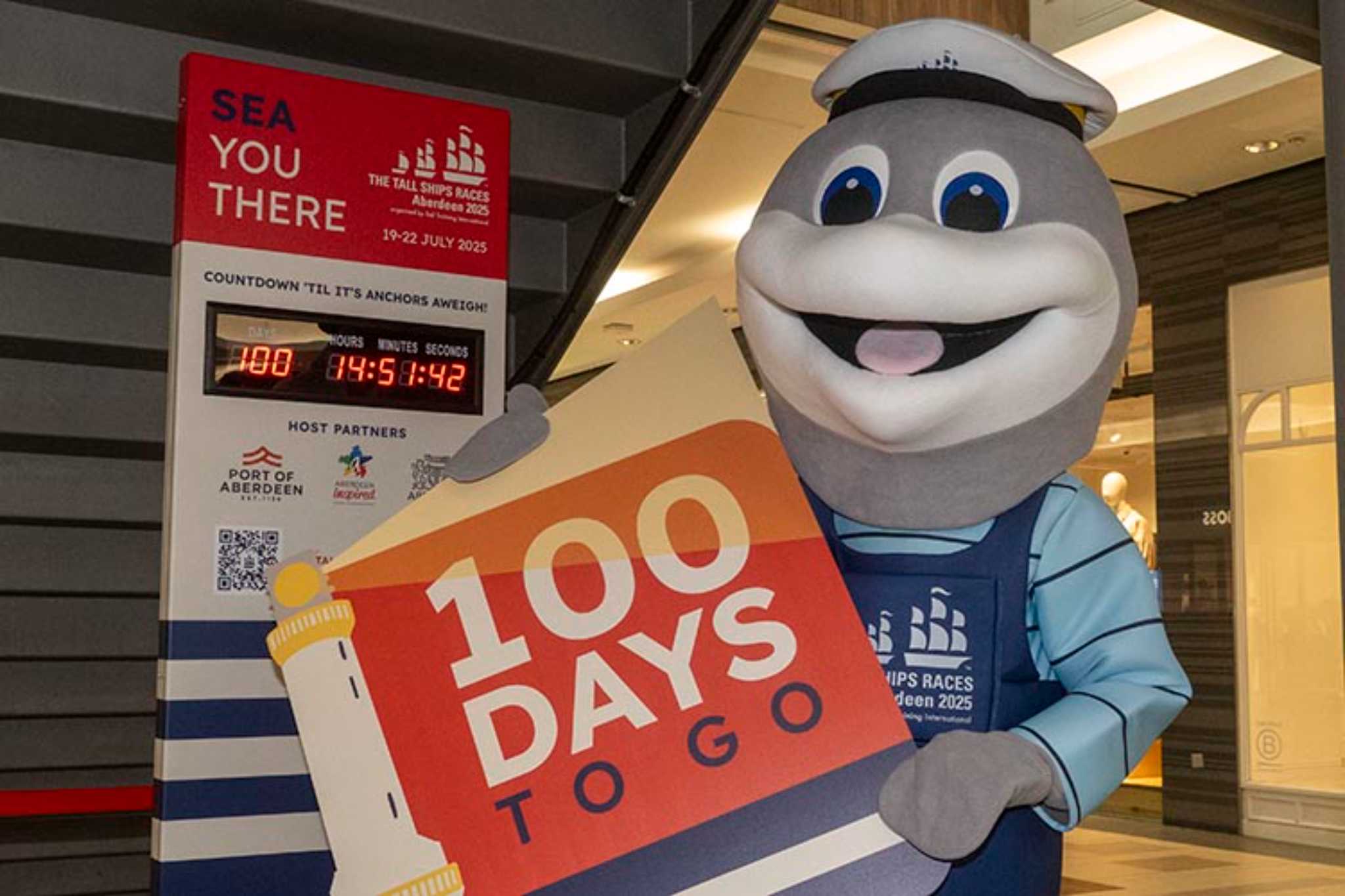 Shark mascot holding a sign