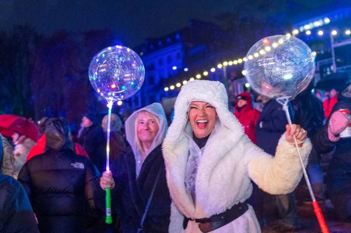 People holding balloons and enjoying a street party