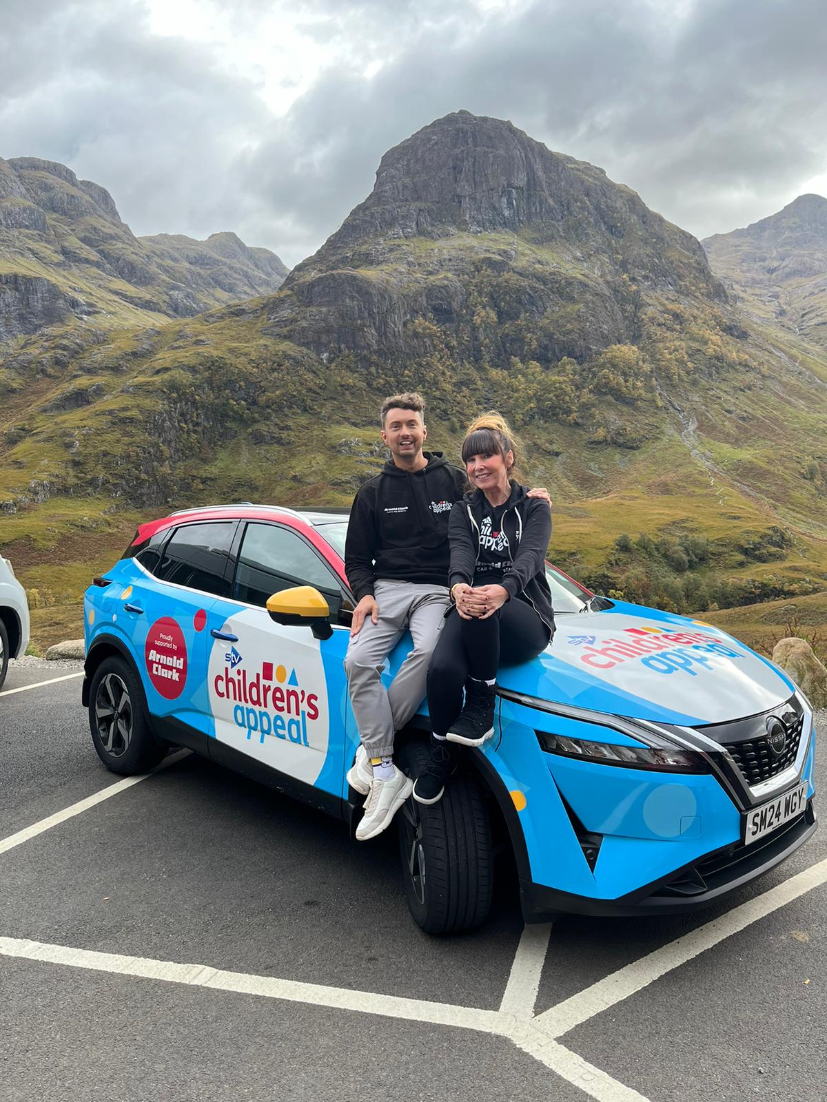 People posing on a branded car