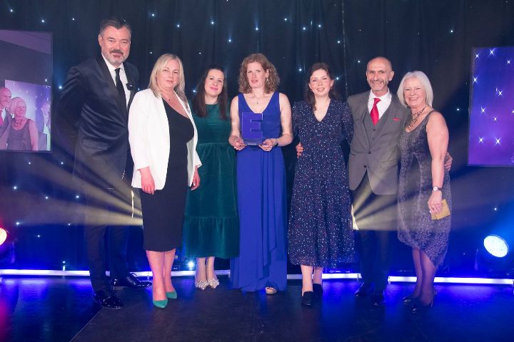 People on stage posing with an award