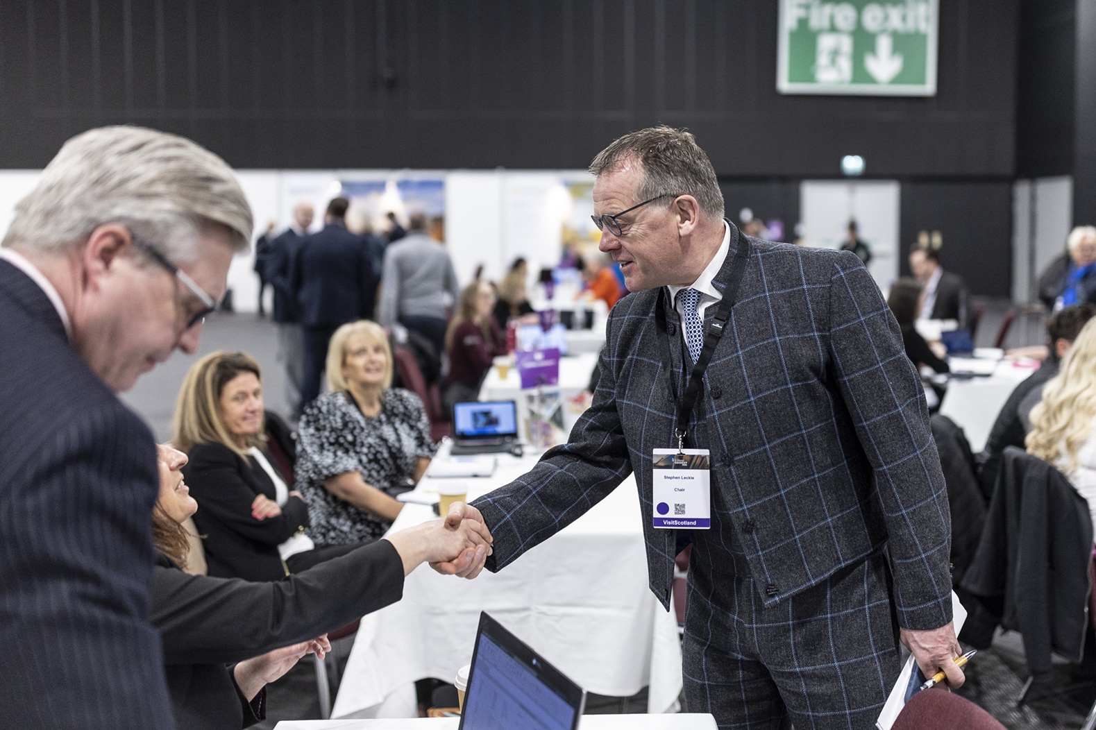 people at a large events meeting shaking hands