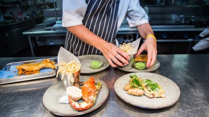 Chef Jamie Nicolson arranges four plates of food Loch Fyne Restaurant and Oyster Bar
