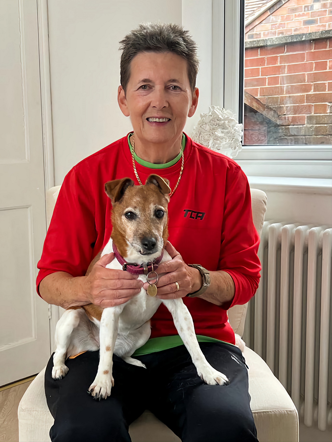 A person sitting holding a dog