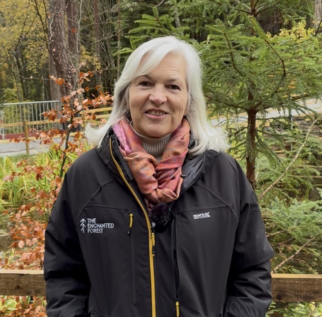 A person standign outside in a forest, during the day and facing the camera