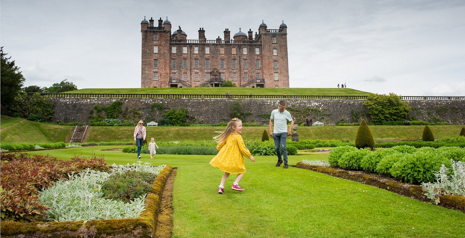 A family is playing in the Drumlanrig Castle Gardens
