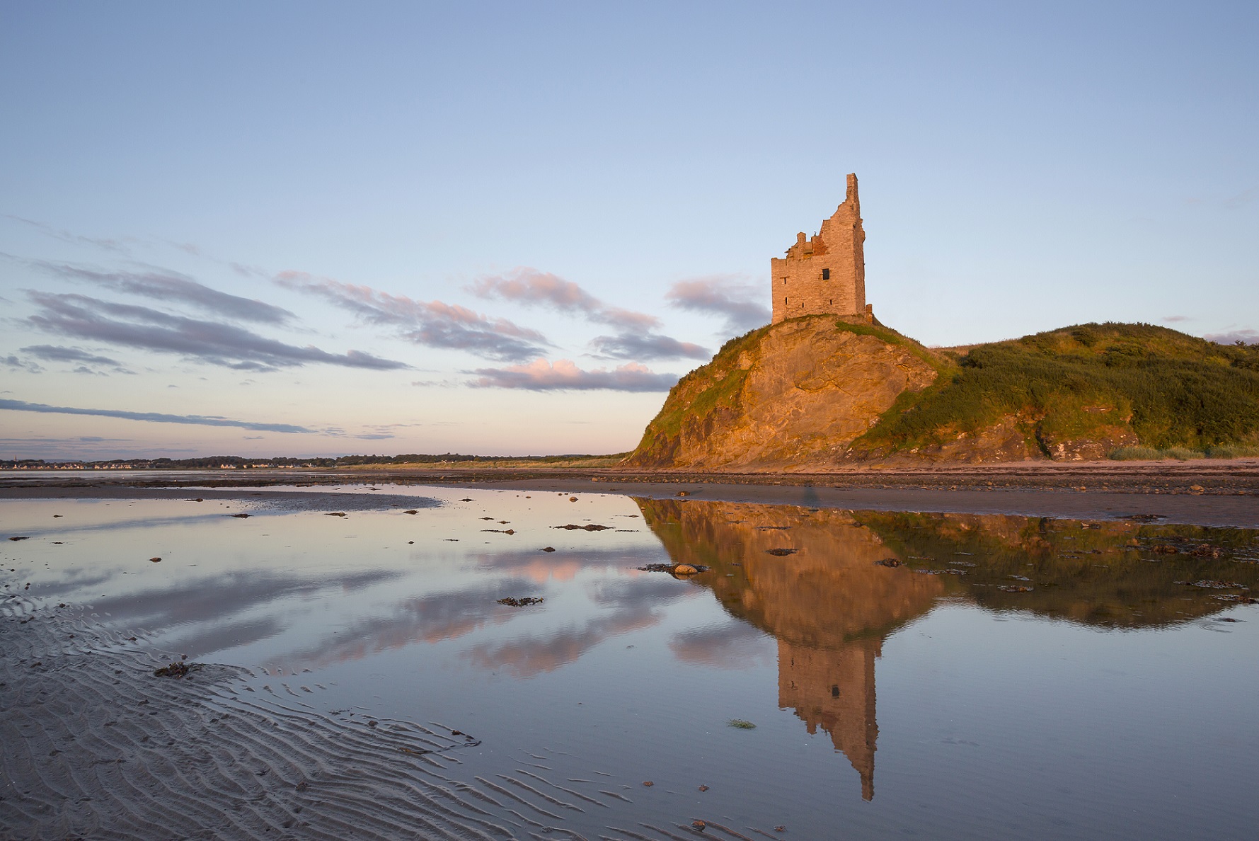 A castle beyond a body of water in the evening