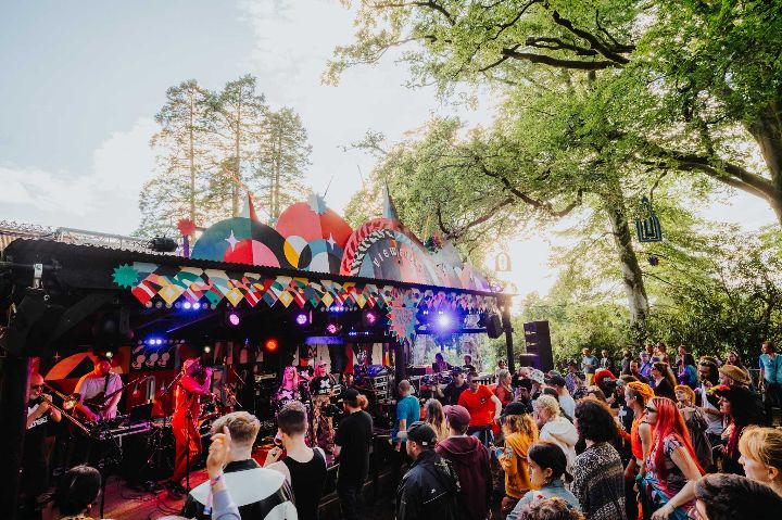 Small festival stage with band being watched by a crowd