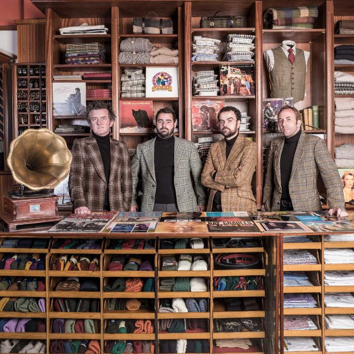 Band posing in tweed