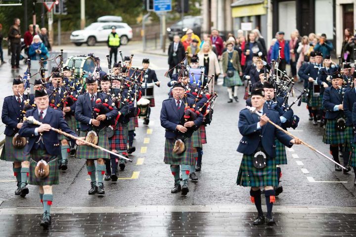 Pipe band marching down a street while playing