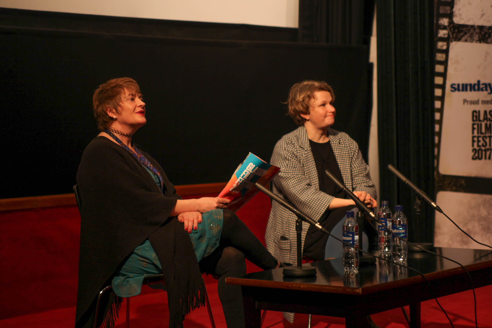 Image of two women sitting facing microphones as the host a Q&A session.