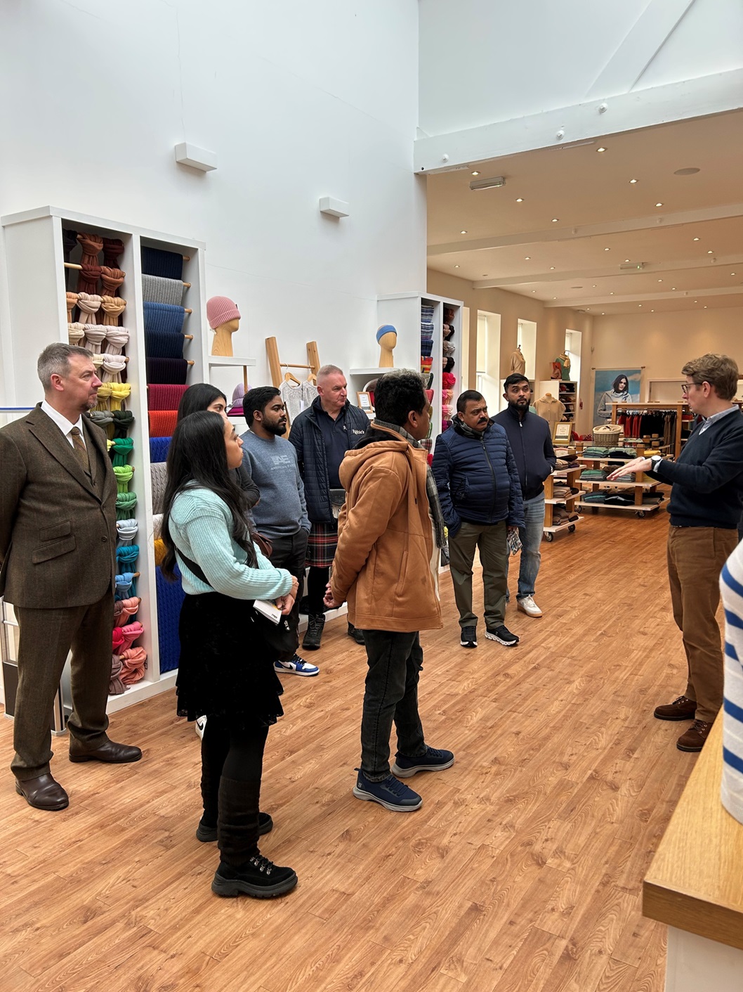 A groiup of people standing inside a building listening to a person giving a tour