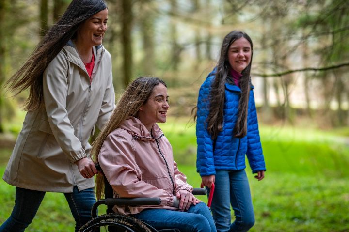 Three individuals, including one woman in a wheelchair, enjoying nature in Craik Forest