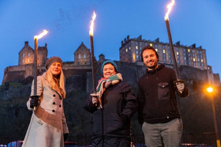 Three people posing with flaming torches
