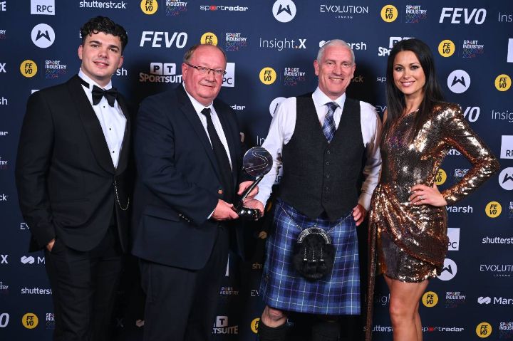 People on stage posing with an award