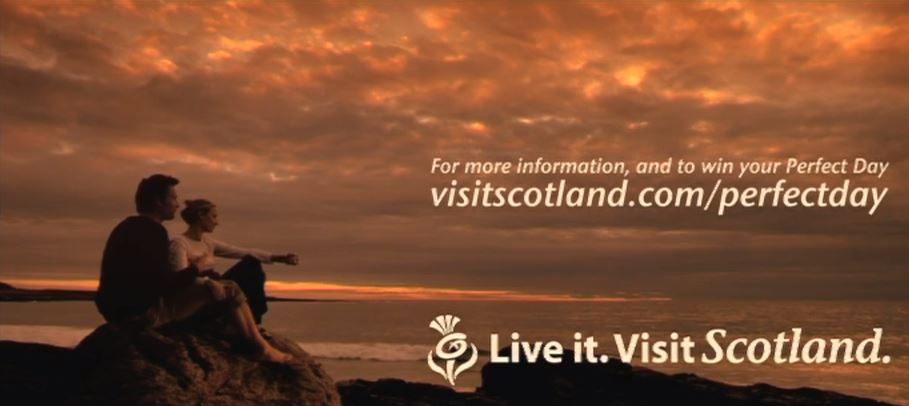 Two people sitting on a rock at dusk