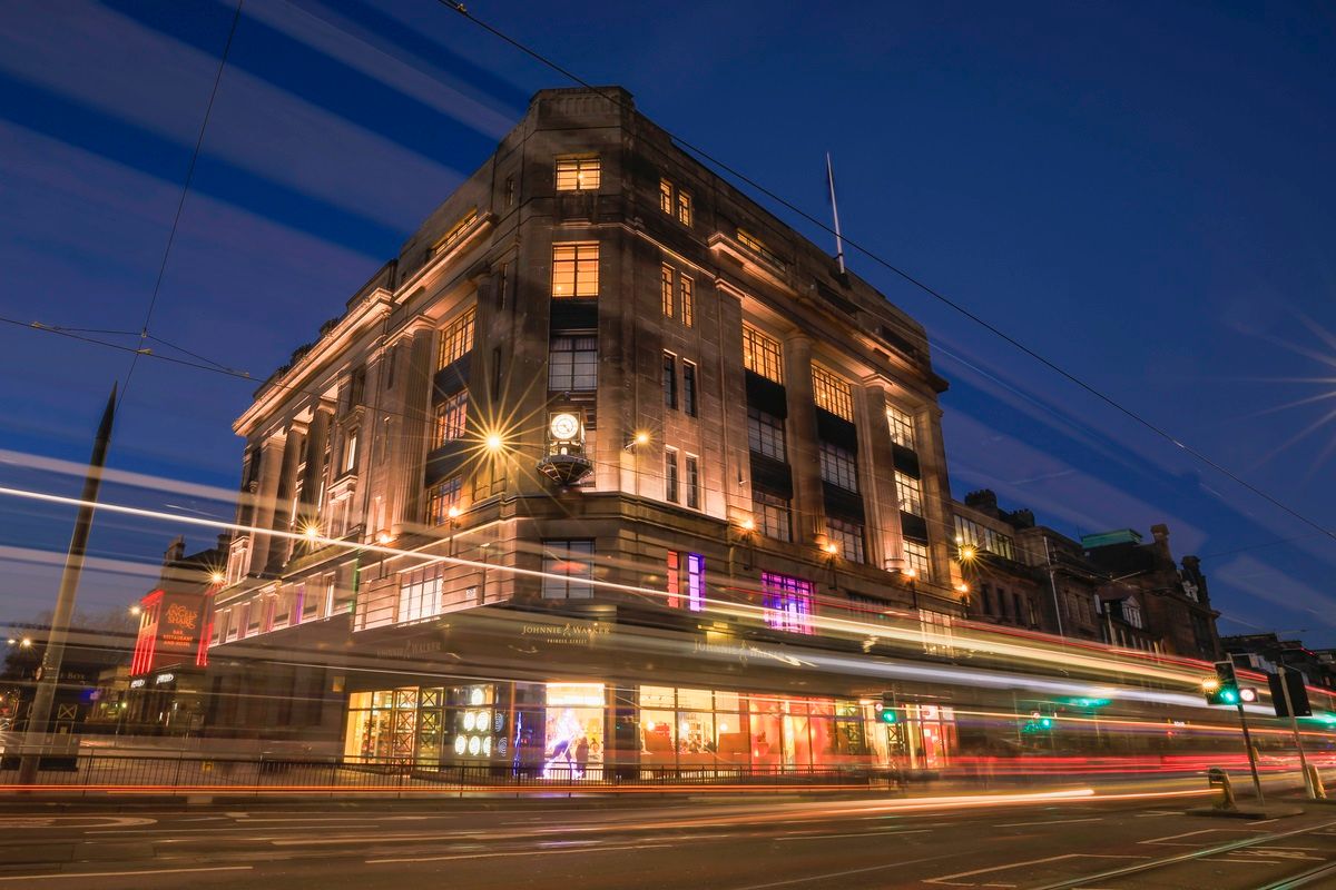 The exterior of the Johnnie Walker Experience on Princes Street in Edinburgh at night