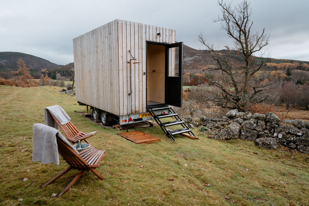 a mobile sauna in a field with a scenic view in the background