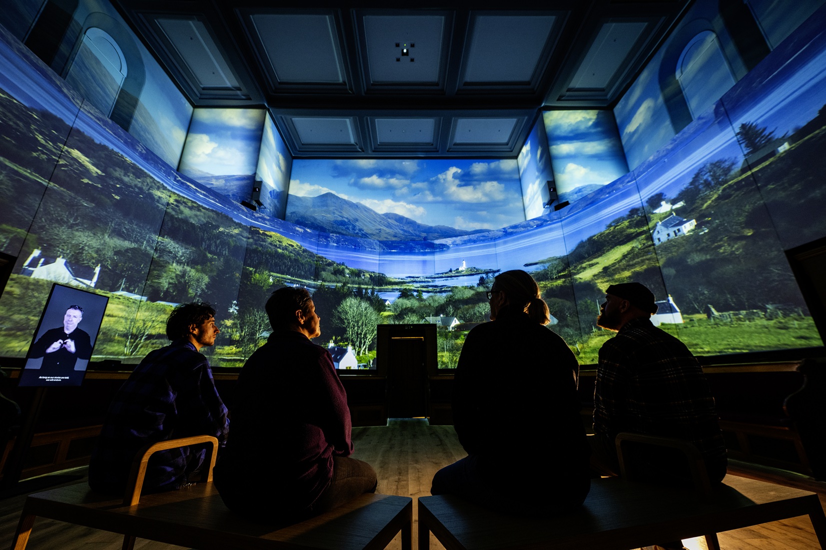a group of people sitting looking up to an immersive experience